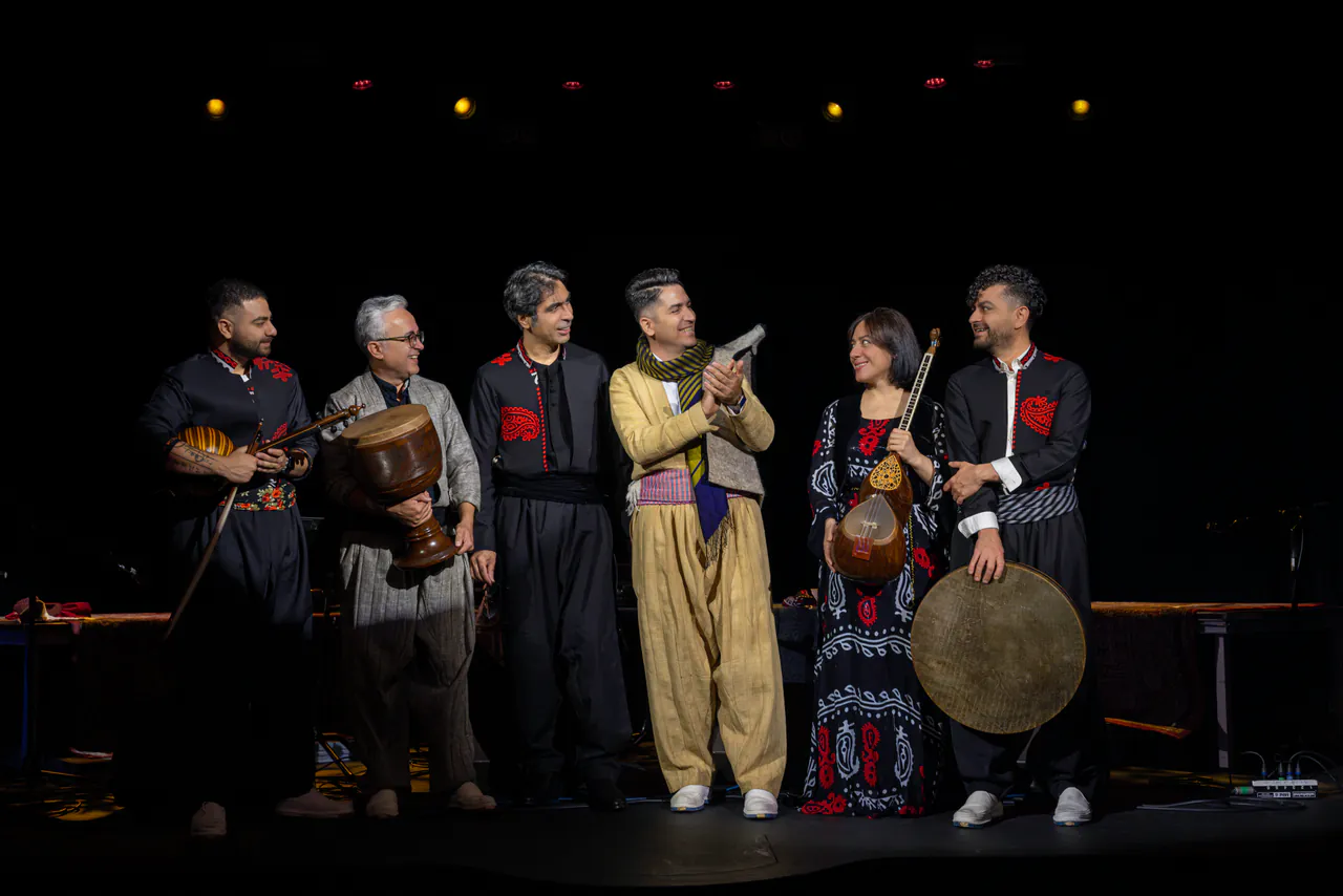 Hawraman musicians in traditional dress with their instruments, archival group photograph
