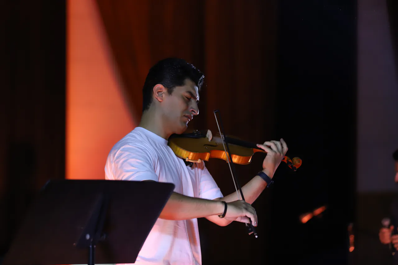 Kasra Kaveh playing violin in concert.