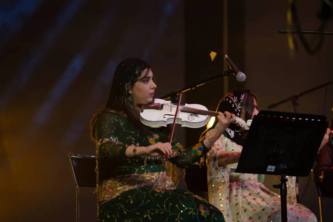 Shno Sharifzadeh performing violin on stage.